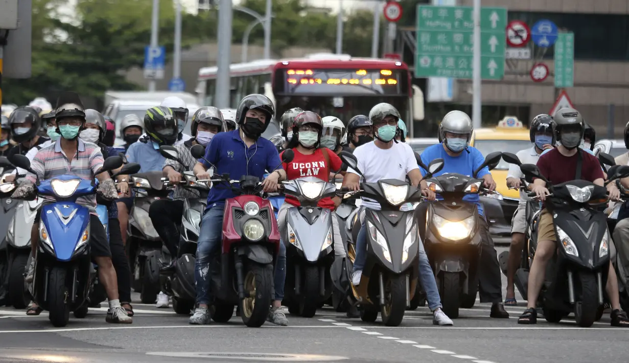 Para pengendara sepeda motor mengenakan masker untuk membantu melindungi diri dari penyebaran virus corona COVID-19 di Taipei, Taiwan, Senin (12/7/2021). Kasus COVID-19 di Taiwan naik ke level tiga. (AP Photo/Chiang Ying-ying)