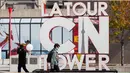 Seorang pria yang memakai masker berjalan melewati papan nama CN Tower di Toronto, Kanada, pada 3 Oktober 2020. CN Tower kembali ditutup untuk umum pada Sabtu (3/10) di tengah melonjaknya kasus COVID-19. (Xinhua/Zou Zheng)