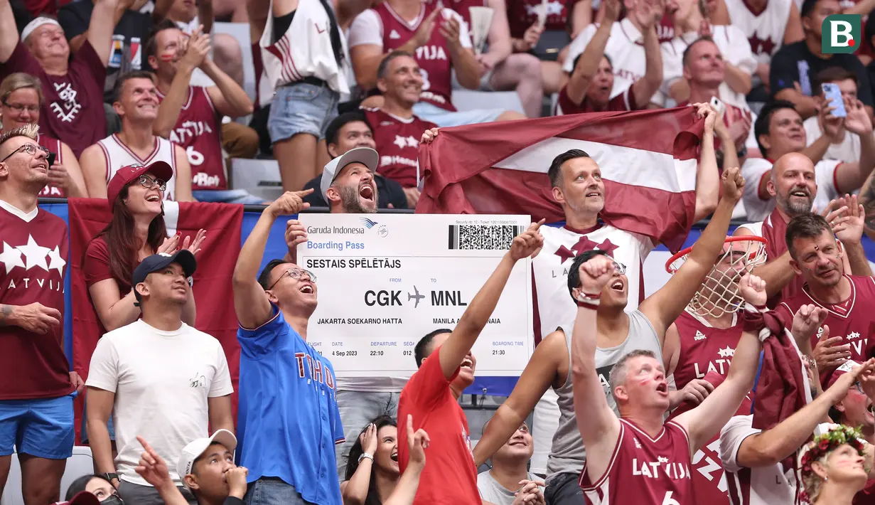 Seorang suporter Latvia memegang cetakan besar tiket pesawat rute Bandara Soekarno Hatta menuju Manila saat laga Grup L Piala Dunia FIBA 2023 antara Latvia melawan Brasil di Indonesia Arena, Senayan, Jakarta, Minggu (03/09/2023). Latvia menang dengan skor 104-84. (Bola.com/Bagaskara Lazuardi)