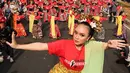Seorang penari diikuti ribuan peserta membawakan Tari Puspanjali dari Bali saat CFD di Senayan, Jakarta, Minggu (12/8). Kegiatan ini digelar menyambut HUT Ke-73 RI dan Asian Games 2018. (Liputan6.com/Fery Pradolo)