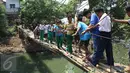 Sejumlah pelajar menyeberangi Kali Angke melewati jembatan rapuh di Kampung Cantiga, Petir, Cipondoh, Tangerang, Rabu (2/9/2015). Jembatan berusia lima tahun tersebut menghubungkan Cipondoh dan Kembangan, Jakarta. (Liputan6.com/Gempur M Surya)