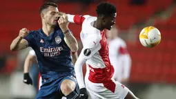 Penyerang Slavia Praha, Peter Olayinka berebut bola dengan gelandang Arsenal, Granit Xhaka pada leg kedua perempat final Liga Europa di Stadion Sinobo, Praha, Jumat (16/4) dini hari WIB.  Arsenal lolos ke semifinal Liga Europa setelah menang telak 4-0 di markas Slavia Praha. (AP Photo/Petr David Jo