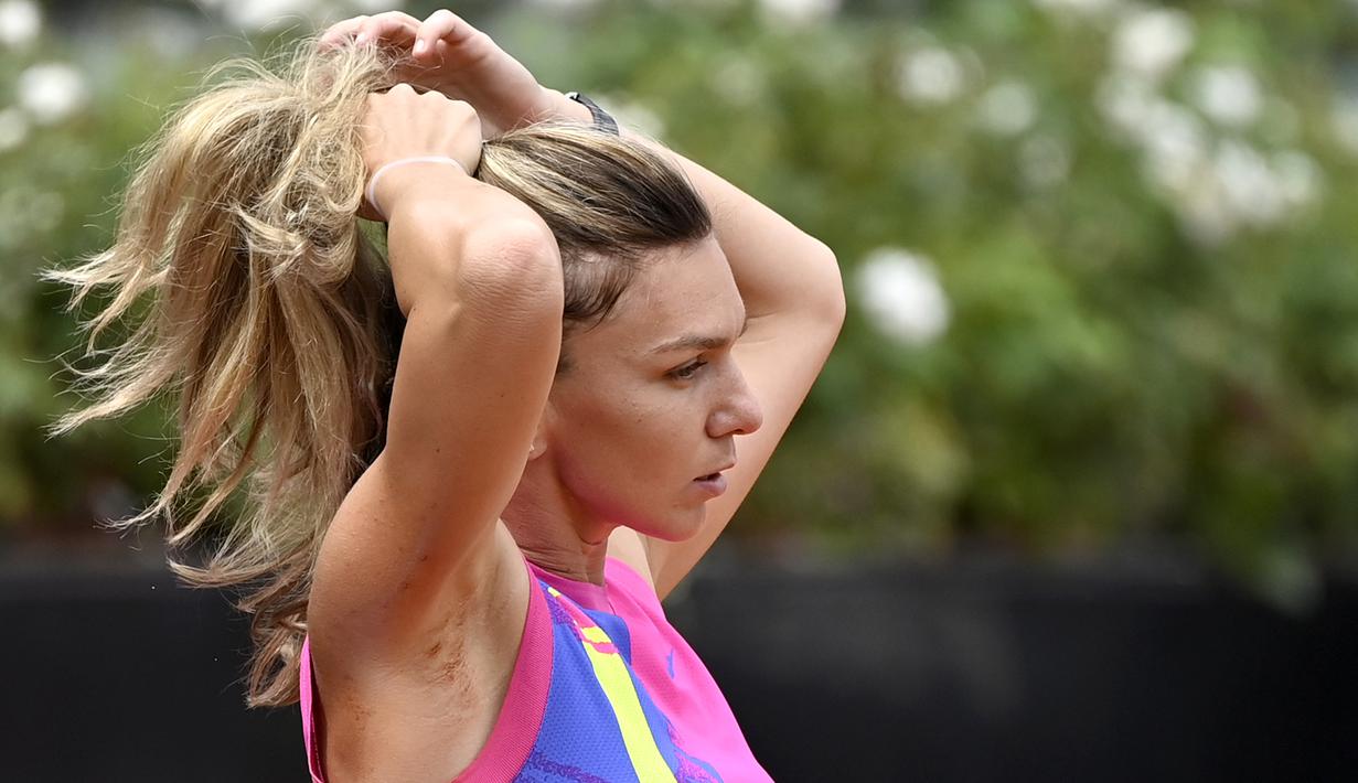 Petenis Romania, Simona Halep, mengikat rambutnya usai pertandingan final Italia Terbuka 2020 di Foro Italico, Roma Italia, Senin (21/9/2020). Simona Halep menjuarai Italia Open 2020 setelah Karolina Pliskova mundur karena cedera pada menit ke-32. (AFP/Riccardo Antimiani/pool)
