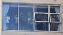Para pemain Leeds United di sebuah jendela di dalam stadion menyapa pendukung mereka untuk merayakan kembalinya klub ke Liga Premier setelah 16 tahun, di Leeds, Inggris utara (17/7/2020). (AFP/Paul Ellis)