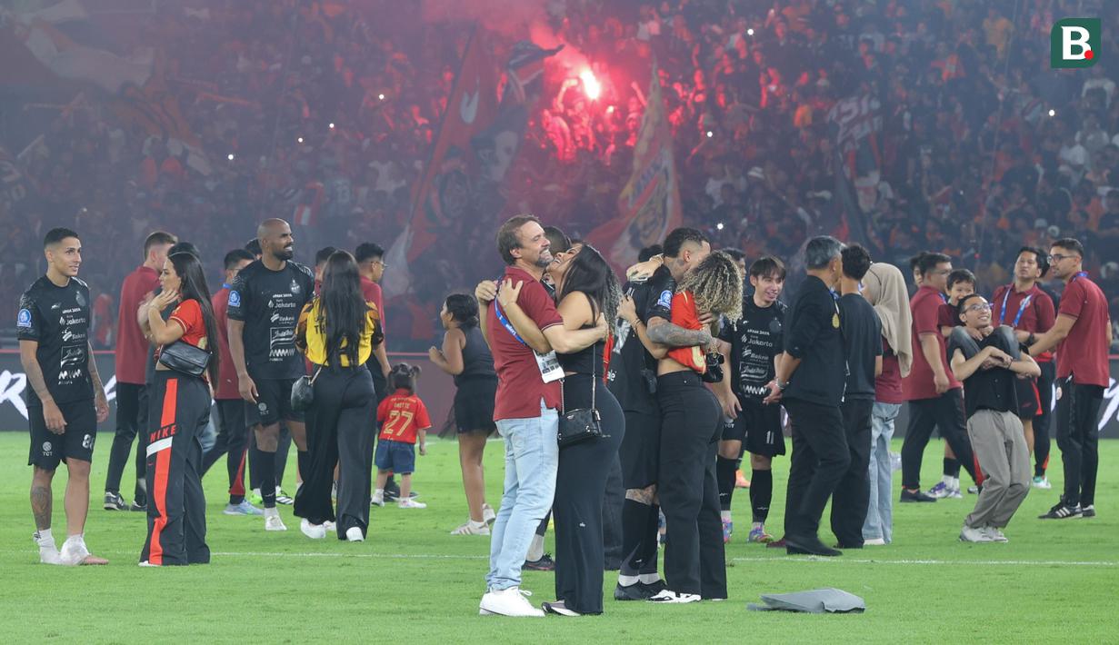 Pelatih Persija Jakarta, Mauricio Souza, memeluk istrinya saat merayakan kemenangan sekaligus ulang tahun ke-97 Persija di Stadion Utama Gelora Bung Karno (SUGBK), Senayan, Jakarta Pusat, Jumat (28/11/2025). (Bola.com/M Iqbal Ichsan)
