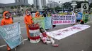 Sejumlah aktivis melakukan teatrikal dengan menyiramkan darah di tubuhnya saat aksi serentak desak Presiden Jokowi deklarasikan Darurat Iklim di kawasan Patung Kuda, Jakarta, Jumat (19/3/2021). Aksi serentak di beberapa lokasi itu untuk menuntut deklarasi darurat iklim. (Liputan6.com/Faizal Fanani)