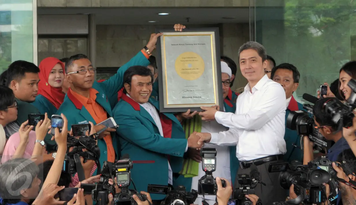 Ketua Umum Partai Idaman, Rhoma Irama menyerahkan plakat piringan hitam kepada pimpinan KPK di depan gedung KPK, Jakarta, Kamis (3/3). Kedatangan Rhoma dalam rangka memberikan dukungan kepada lembaga antirasuah tersebut. (Liputan6.com/Helmi Afandi)