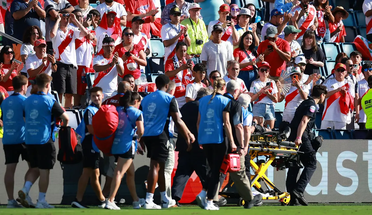 Fans Peru memberikan tepuk tangan saat asisten wasit Humberto Panjoj ditandu keluar lapangan setelah mengalami pingsan pada laga Grup A Copa America 2024 antara Peru melawan Kanada di Children's Mercy Park, Kansas City, Kansas, Selasa (25/06/2024) waktu setempat. (AFP/Getty Images/Hector Vivas)