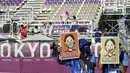 Relawan menunjukkan spanduk arahan untuk para atlet sebelum upacara medali kompetisi beregu putri selama Olimpiade Tokyo 2020 di Tokyo pada 25 Juli 2021. Relawan atau volunteer merupakan salah satu kunci suksesnya suatu perhelatan, tak terkecuali Olimpiade Tokyo 2020 ini. (AP/Alessandra Tarantino)
