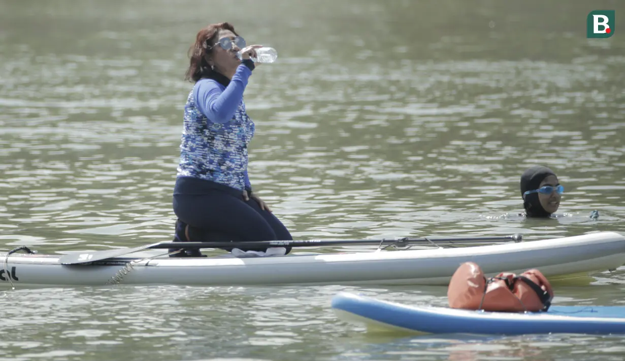 Menteri Kelautan dan Perikanan, Susi Pudjiastuti, melepas dahaga saat bermain paddle board di Danau Sunter, Jakarta, Minggu (25/2/2018). Kegiatan ini dilakukan dalam rangka Festival Danau Sunter. (Bola.com/Okie Prabhowo)