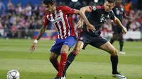 Gelandang Atletico Madrid, Augusto Fernandez (kiri) berduel dengan striker Bayern Munchen, Robert Lewandowski, pada laga Leg 1 Babak Semifinal Liga Champions 2015-2016, di Stadion Vicente Calderon, Kamis (28/4/2016) dini hari WIB. Permainan lini tengah At