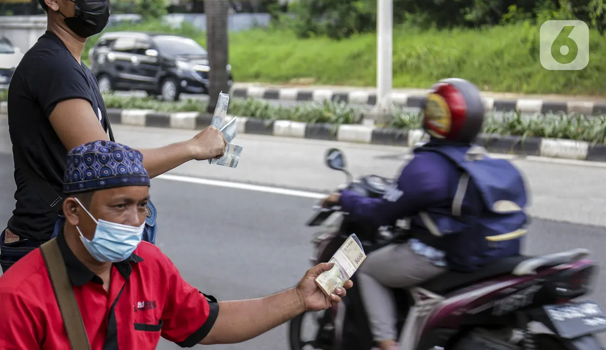 Penjual jasa penukaran uang menawarkan uang baru dalam berbagai pecahan di kawasan Pondok Indah, Jakarta, Kamis (6/5/2021). Uang baru dalam berbagai pecahan banyak dibutuhkan saat Lebaran untuk dibagikan kepada anak sanak-saudara saat silaturahmi. (Liputan6.com/Johan Tallo)