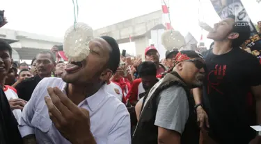 Aktor Tora Sudiro, Vino G Bastian dan Indro Warkop mengikuti lomba makan kerupuk pada Festival Kalimalang di Jakarta, Kamis (17/8). Mereka menghadiri festival Kalimalang dalam rangka promo film Warkop DKI: Reborn Part 2. (Liputan6.com/Herman Zakharia)