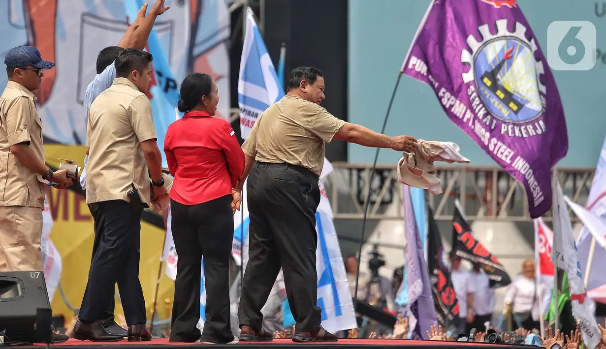 Presiden Prabowo Subianto (kanan-baju coklat) memberikan kemeja yang dikenakannya kepada peserta aksi perayaan Hari Buruh Internasional 2025 di kawasan Monumen Nasional (Monas), Jakarta, Kamis (1/5/2025). (Liputan6.com/Angga Yuniar)