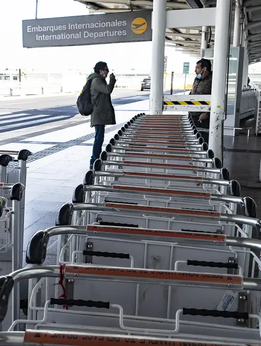 Penumpang terlihat di Bandara Internasional Arturo Merino Benitez di Santiago setelah Chile menutup perbatasannya, Senin (5/4/2021). Kasus COVID-19 melonjak di Chile meskipun negara tersebut diketahui sebagai salah satu negara dengan proses vaksinasi tercepat di dunia. (MARTIN BERNETTI/AFP)