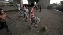 Anak-anak bermain sepak bola di kolong jalan Tol Lingkar Utara, Kalibaru, Cilincing, Jakarta, Kamis (28/3). Lahan di kolong jalan tol tersebut rencananya oleh Pemkot Jakarta Utara akan disulap menjadi ruang terbuka hijau bernama Taman Maju Bersama (TMB). (merdeka.com/Iqbal S Nugroho)