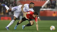 Penyerang Real Madrid, Rodrygo berebut bola dengan pemain Mallorca, Brian Olivan pada pertandingan lanjutan La Liga Spanyol di Palma de Mallorca, Spanyol, Selasa (15/3/2022). Madrid menang telak atas Mallorca 3-0. (AP Photo/Francisco Ubilla)