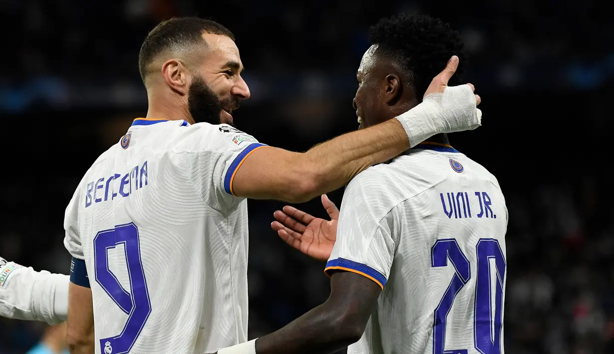 Karim Benzema dan Vinicius Jr. Duet maut Karim Benzema dan Vinicius Jr juga menggila bersama Real Madrid. Keduanya berkontribusi menjadi penyumbang gol terbanyak untuk Los Blancos. Karim Benzema total melesakkan 27 gol dan 12 assist, sedangkan tandemnya, Vinicius Jr mampu menciptakan 17 gol dan 13 assist pada musim 2021-2022. (AFP/Pierre-Philippe Marcou)