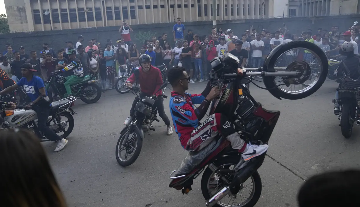 Pengendara sepeda motor tampil di atas sepeda motor mereka selama pameran di lingkungan El Valle Caracas, Venezuela, Sabtu (31/7/2021). (AP Photo/Ariana Cubillos)