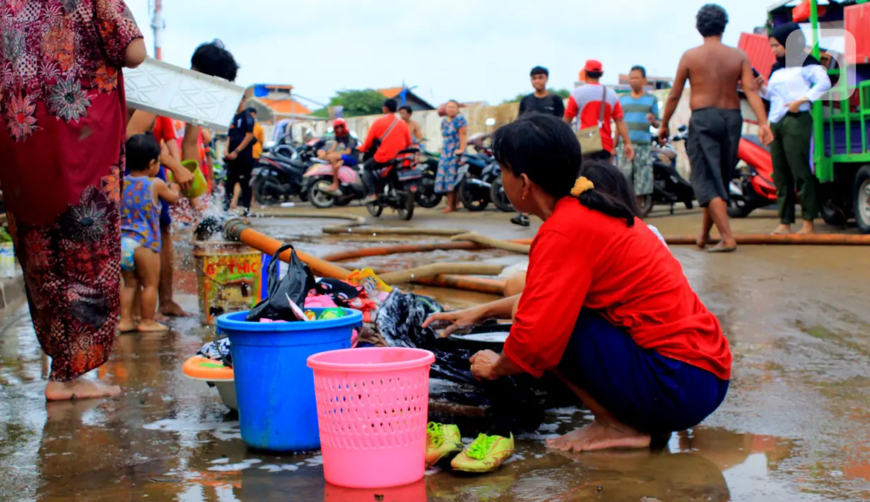 Warga mencuci usai banjir melanda Kampung Melayu, Jakarta, Jumat (3/1/2020). Banjir yang melanda Kampung Melayu menyisakan sisa sampah dan lumpur. (merdeka.com/Magang/Muhammad Fayyadh)