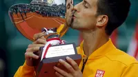 Novak Djokovic mencium trofi Monte Carlo Masters (REUTERS/Jean-Paul Pelissier)