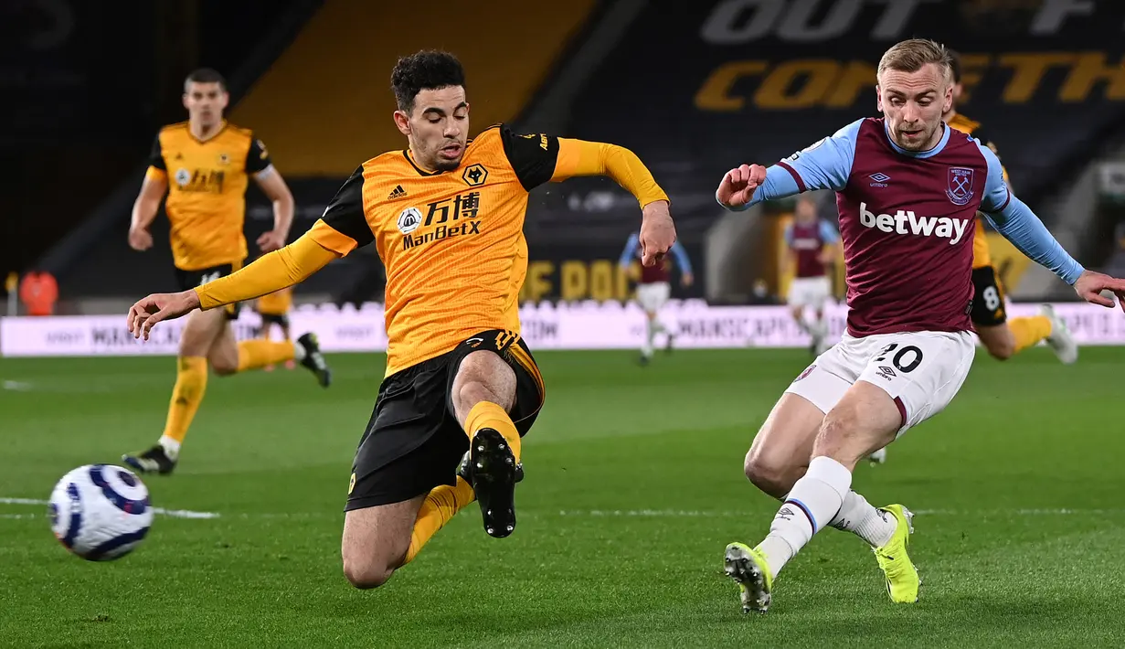 Striker West Ham United, Jarrod Bowen (kanan) melepaskan tendangan yang berbuah gol ketiga timnya ke gawang Wolverhampton Wanderers dalam laga lanjutan Liga Inggris 2020/2021 pekan ke-30 di Molineux Stadium, Senin (5/4/2021). West Ham menang 3-2 atas Wolverhampton. (AFP/Laurence Griffiths/Pool)