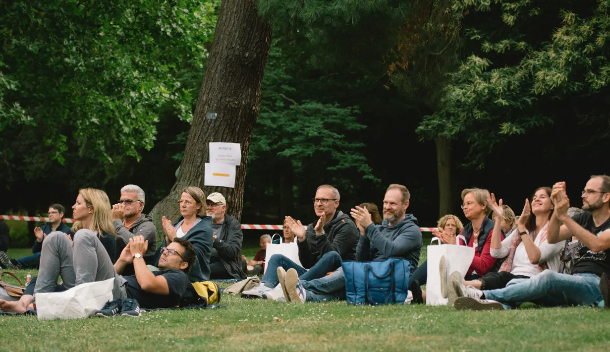 Warga menikmati konser yang diselenggarakan oleh Beethoven Orchestra Bonn di lapangan rumput sebuah taman di Bonn, Jerman, pada 28 Juni 2020. Konser itu digelar untuk memperingati 250 tahun kelahiran komponis sekaligus pianis Ludwig van Beethoven. (Xinhua/Tang Ying)