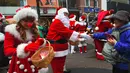 Santa Claus bersalaman dengan  seorang wanita saat mempromosikan musim Natal di distrik perbelanjaa,  Seoul (13/11). Meski sebagian besar penduduknya adalah umat Budha, anak muda Korsel menikmati perayaan musim Natal tersebut. (AFP Photo/Jung Yeon-Je)