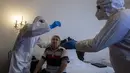 Petugas kesehatan dengan APD merawat tunawisma pasien virus corona di sebuah kamar hotel di Praha, Senin (8/3/2021). Hotel yang dulunya menjadi tujuan wisatawan internasional itu kini membuka pintunya bagi para tunawisma yang sakit terpapar Covid-19 atau perlu karantina. (MICHAL CIZEK/AFP)