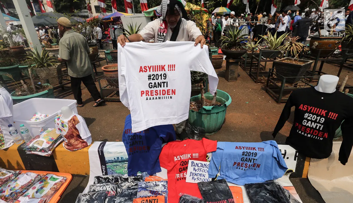 Pedagang menjual kaos #2019GantiPresiden di halaman Masjid Istiqlal, Jakarta, Jumat (10/8). Pedagang menjual kaos lengan panjang dan pendek berwarna putih, hitam, biru dan merah. (Liputan6.com/Fery Pradolo)