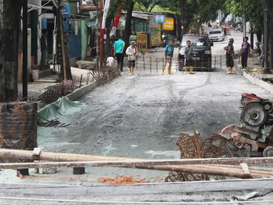 Pekerja menyelesaikan pembetonan Jalan Pejaten Raya di Jakarta Selatan (22/11). Proyek pembetonan dan peninggian badan jalan ini guna mengantisipasi banjir yang kerap terjadi di kawasan tersebut. (Liputan6.com/Immanuel Antonius)
