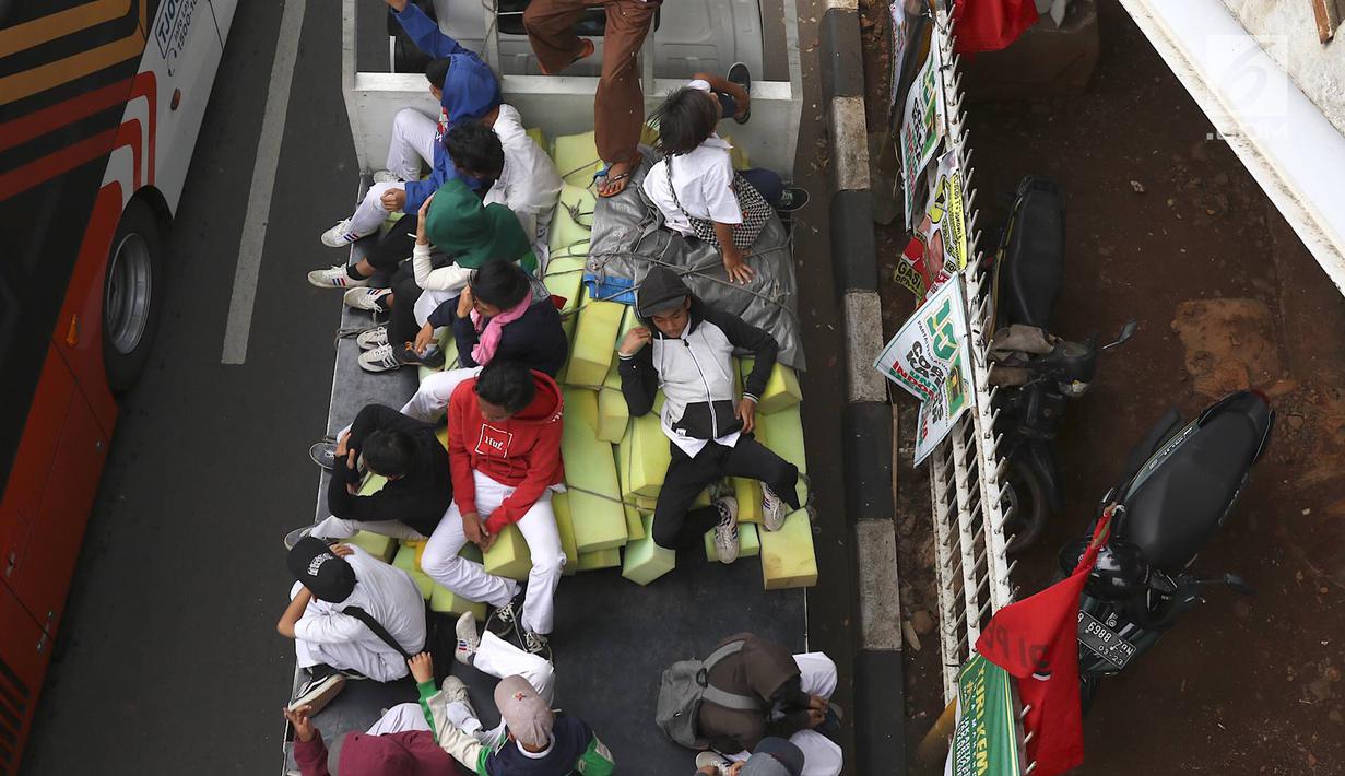 Pelajar menumpang truk terbuka yang melintas di kawasan Lenteng Agung, Jakarta, Senin (8/4). Perilaku buruk tersebut membahayakan keselamatan diri mereka dan pengguna jalan lain. (Liputan6.com/Immanuel Antonius)