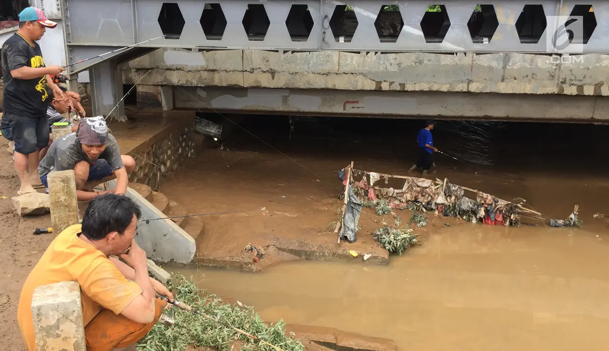Warga memancing ikan dari Sungai Ciliwung yang meluap di Rawajati,Jakarta, Selasa (6/2). Warga memilih bantaran sungai sebagai lokasi untuk memancing. (Liputan6.com/Immanuel Antonius)