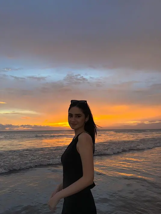 Mengenakan jumpsuit pendek berwarna hitam, paras blasteran Syifa Hadju berpadu dengan sunset di sebuah pantai yang tak disebutkan namanya. (Liputan6.com/IG/@syifahadju)