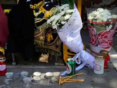 Lilin dan bunga tergeletak pada lokasi di mana seorang suporter sepak bola Yunani meninggal dalam bentrokan antara pendukung AEK Athens dan Dinamo Zagreb di pinggiran Nea Philadelphia, Athena, Yunani, Selasa (8/8/2023). (AP Photo/Thanassis Stavrakis)