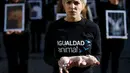 Seorang akivitis dari Igualdad Animal mebawa anak Babi saat melakukan aksi protes di di Madrid, Spanyol (10/12). Mereka memprotes anggapan hewan sebagai properti atau peliharaan saja yang bernilai lebih rendah dari manusia. (Reuters/Javier Barbancho)