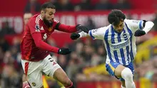 Bek Manchester United, Noussair Mazraoui beradu kecepatan melawan gelandang Brighton, Kaoru Mitoma. (c) AP Photo/Dave Thompson