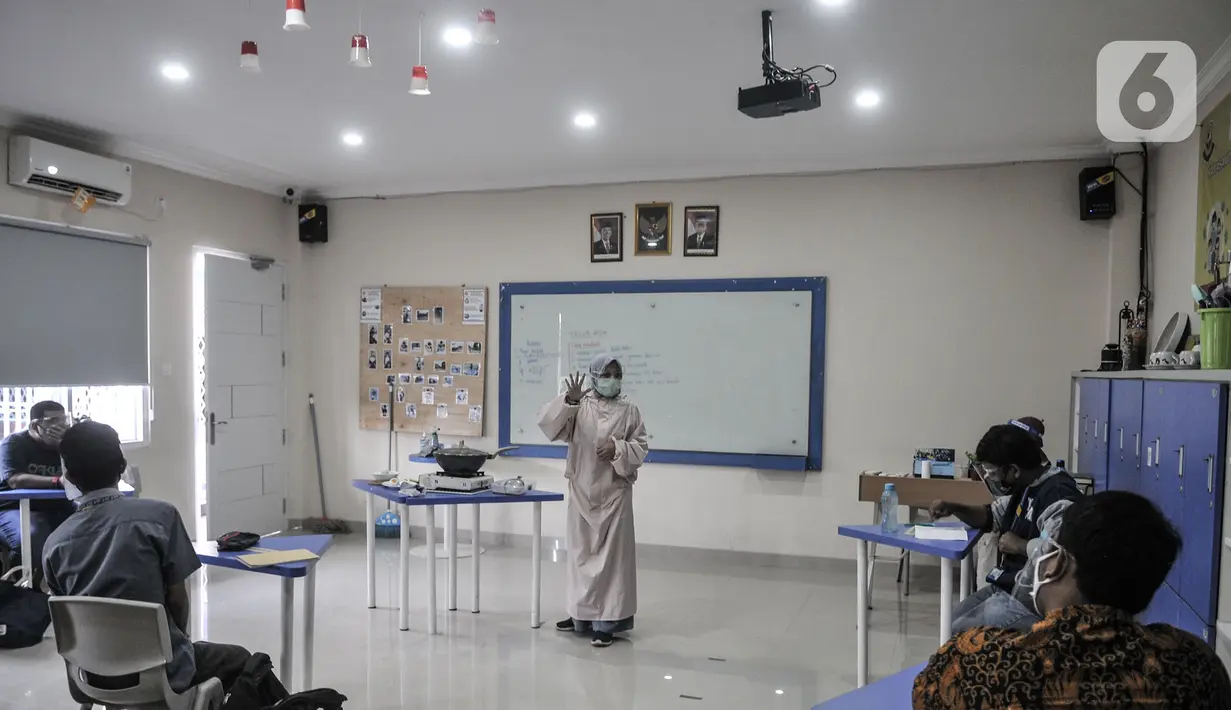 Terapis atau pengajar membimbing mahasiswa berkebutuhan khusus dalam proses pembuatan telur asin saat kelas terapi mata kuliah wirausaha di Lembaga Pendidikan dan Keterampilan Kampusnya Manusia, Kranggan, Bekasi, Jawa Barat, Kamis (3/12/2020). (merdeka.com/Iqbal S. Nugroho)