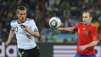 Lukas Podolski (kiri) berjibaku dengan Andres Iniesta di level internasional. (AFP/Gabriel Bouys)