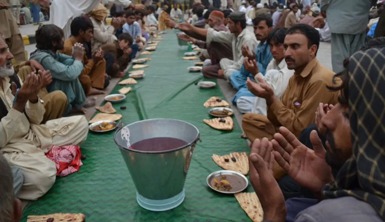  Roti dan kari khas Pakistan sebagai menu buka puasa bersama. Para peserta berdoa bersama sebelum acara buka puasa bersama dimulai, Quetta, Rabu (2/7/2014) (AFP PHOTO/BANARAS KHAN)