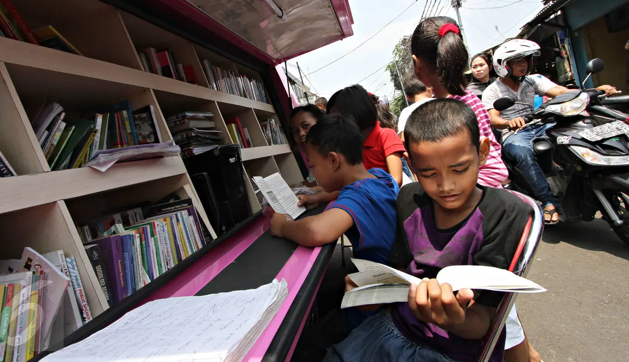 Anak-anak membaca buku yang disediakan perpustakaan keliling di kawasan Tanah Abang, Jakarta, Minggu (11/10). Keberadaan perpustakaan keliling untuk meningkatkan minat baca pada anak-anak. (Liputan6.com/Immanuel Antonius)