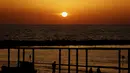 Orang-orang menyaksikan matahari terbenam di kota pesisir Mediterania Israel Netanya, utara Tel Aviv (8/6/2021). Letak kota ini yang berjarak 14 kilometer dari pantai menjadikan kota ini sebagai tempat wisata yang populer. (AFP/ Jack Guez)
