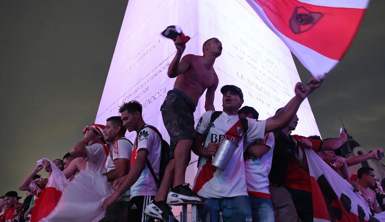 Euforia Suporter River Plate saat merayakan gelar juara Copa Libertadores di Obelisk, Buenos Aires, Argentina, Minggu (9/12). River Plate merebut gelar juara Copa Libertadores usai menaklukkan Boca Juniors dengan skor 3-1. (AP Photo/Gustavo Garello)