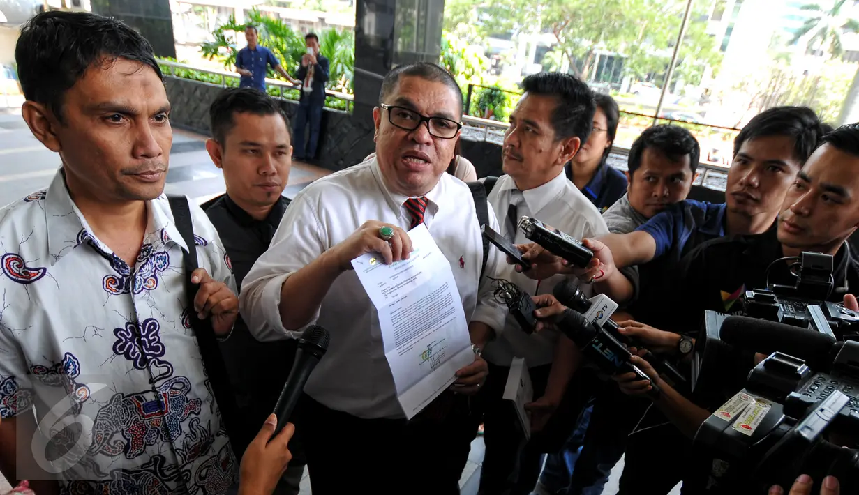 Pengacara, Razman Arief Nasution (tengah) memperlihatkan surat pemberitahuan di Gedung KPK, Jakarta, Kamis (23/7/2015). Razman mendampingi anak buah Gubernur Sumut Gatot Pujo Nugroho, Mustofa (kiri) untuk menjalani pemeriksaan. (Liputan6.com/Yoppy Renato)