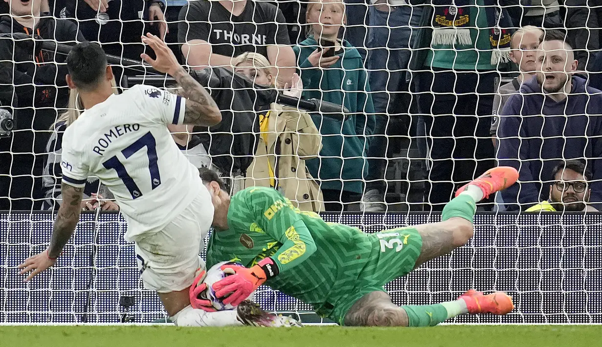 Kiper Manchester City, Ederson Moraes berhasil menangkap bola dari ancaman bek Tottenham Hotspur, Cristian Romero pada laga tunda pekan ke-34 Liga Inggris 2023/2024 di Tottenham Hotspur Stadium, London, Selasa (14/5/2024). (AP Photo/Kin Cheung)