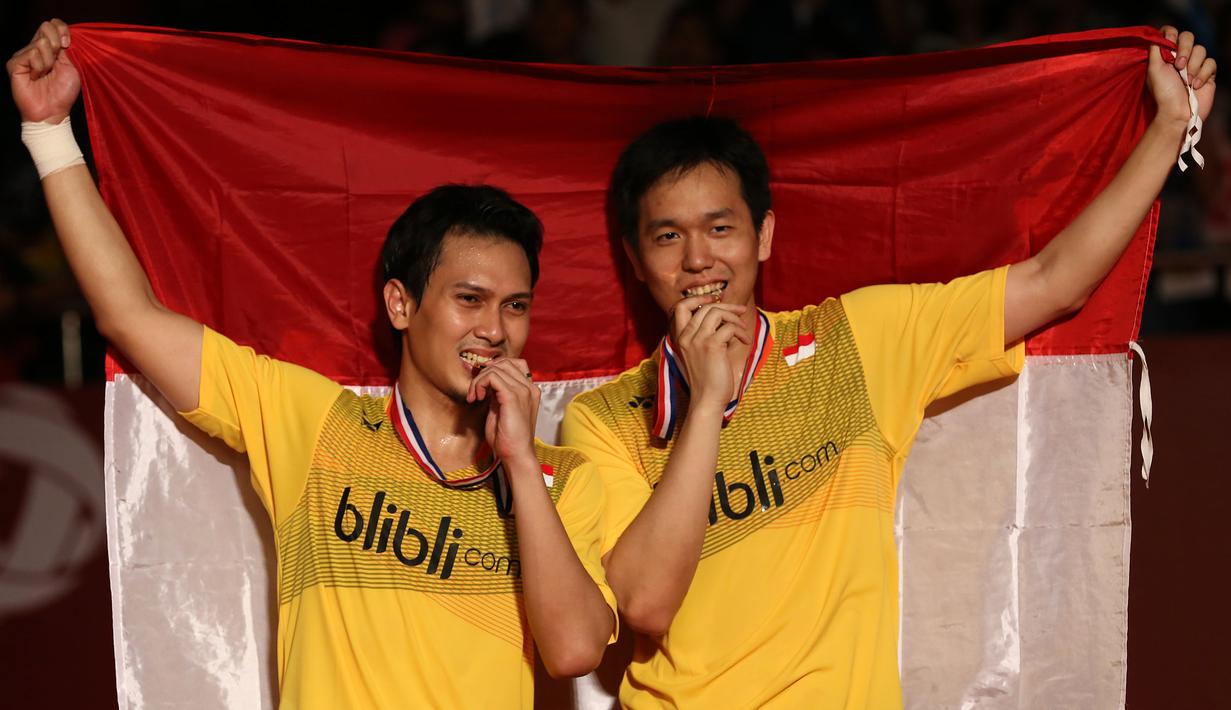 Mohammad Ahsan/Hendra Setiawan, berpose dengan medali emas Kejuaraan Dunia Bulutangkis 2015 setelah mengalahkan pasangan Tiongkok, Liu Xiaolong/Qiu Zihan di Istora Gelora Bung Karno, Senayan, Jakarta. Minggu (16/8/2015). (Bola.com/Arief Bagus)