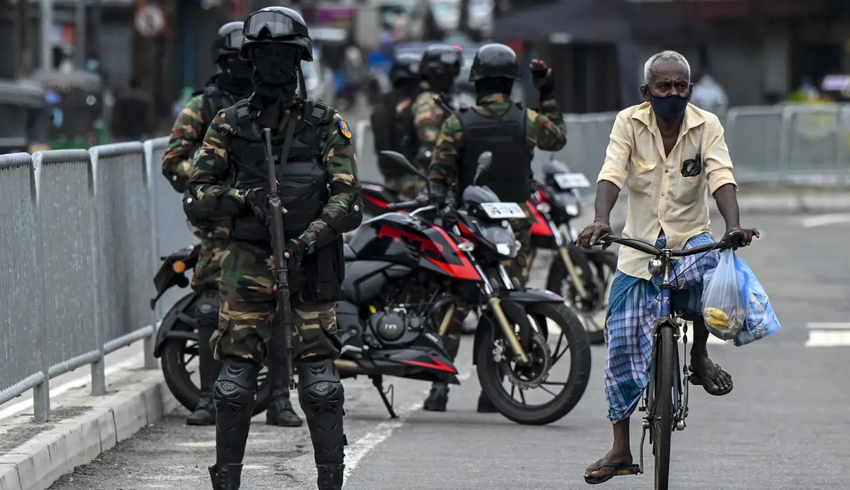 Tentara Sri Lanka berjaga-jaga di pos pemeriksaan saat negara itu bersiap untuk lockdown di Kolombo, Selasa (25/5/2021). Sri Lanka bersiap menerapkan lockdown ketat selama dua minggu untuk menekan penyebaran corona Covid-19. (ISHARA S. KODIKARA / AFP)