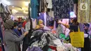 Calon pembeli memilih pakaian bekas di salah satu kios Pasar Senen Blok III, Jakarta, Kamis (11/6/2020). Pasar yang tetap buka saat PSBB dengan pembatasan jam operasional ini akan kembali dibuka secara normal pada 15 Juni 2020 dengan aturan protokol kesehatan COVID-19. (Liputan6.com/Herman Zakharia)