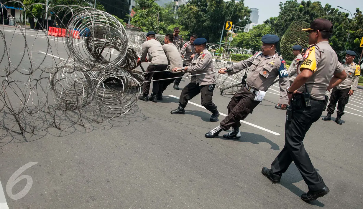 Polisi memasang kawat berduri pada peringatan May Day di depan Istana Negara, Jakarta, Senin (1/5). Istana Negara menjadi titik konsentrasi puluhan ribu buruh yang memperingati Hari Buruh Internasional. (Liputan6.com/Gempur M Surya)