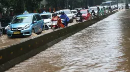 Kendaraan terjebak kemacetan di tengah banjir yang melanda Jalan Lapangan Banteng Utara, Jakarta, Kamis (15/2). Hujan deras dan buruknya drainase menyebabkan kawasan tersebut banjir hingga setinggi lutut orang dewasa. (Liputan6.com/Immanuel Antonius)